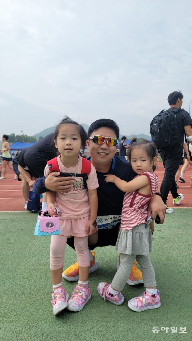 공주백제마라톤 10km에 참여한 유승제 씨가 대회 전 응원을 온 두 딸과 함께 포즈를 취했다. 공주=강동웅 기자 leper@donga.com