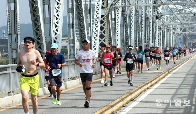 18일 공주백제마라톤에 참가한 선수들이 금강교를 힘차게 건너 달리고 있다. 공주=신원건 기자 laputa@donga.com
