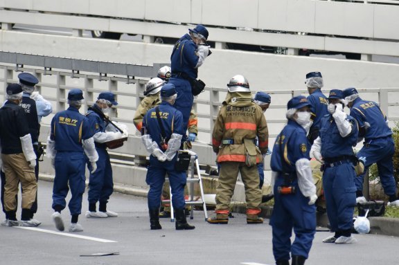 21일 오전 일본 도쿄 총리 관저 인근 도로에서 분신을 시도한 것으로 보이는 남성이 발견돼 병원에 옮겨진 가운데 경찰과 소방관들이 사건 현장을 조사하고 있다. 현장에서는 아베 신조 전 총리 국장을 반대한다고 쓰인 문서가 발견됐다.  도쿄=AP 교도