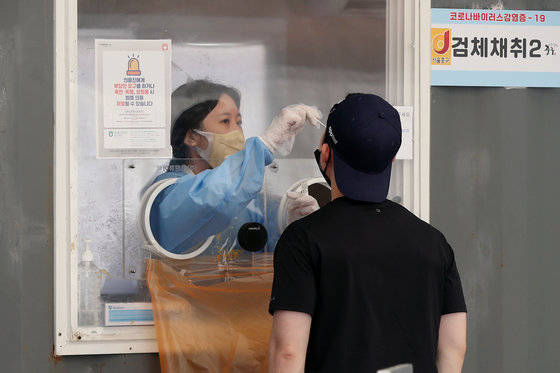 25일 오후 서울 중구 서울역광장에 마련된 신종 코로나바이러스 감염증(코로나19) 선별검사소를 찾은 한 시민이 검체채취를 받고 있다. 2022.9.25 뉴스1