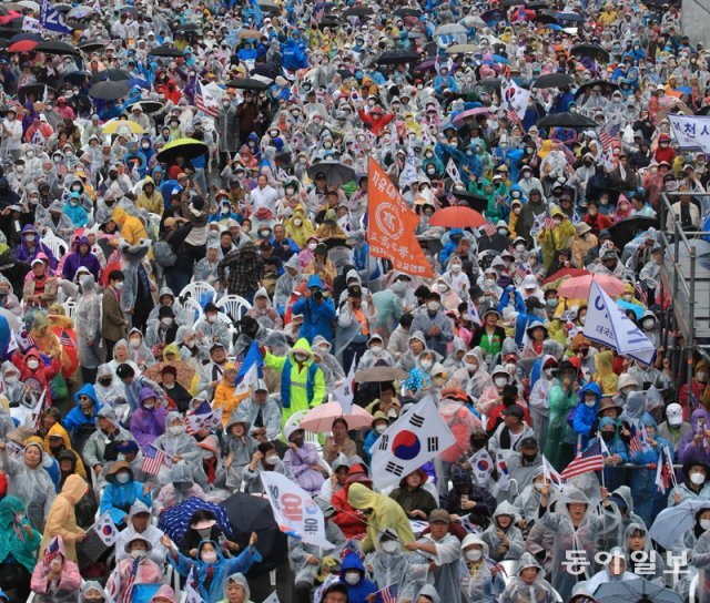 개천절 연휴 마지막 날인 3일 오후 서울 중구 세종대로에서 보수 단체 회원들이 우비를 착용하거나 
우산을 든 채 집회를 하고 있다. 이날 집회에는 3만4000여 명(경찰 추산)이 모였다. 장승윤 기자 
tomato99@donga.com