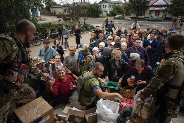 2일(현지시간) 우크라이나 군인들이 최근 회복한 이지움 지역에서 주민들에게 생필품 등을 나눠주고 있다. AP=뉴시스