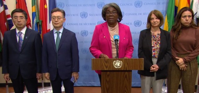 린다 토머스-그린필드 주유엔 미국 대사(가운데)가 북한의 미사일 도발을 규탄하는 성명을 읽고 있다. 왼쪽편에  이시카네 기미히로 일본 대사와 황준국 한국대사가 서 있다. UN 웹TV 캡처