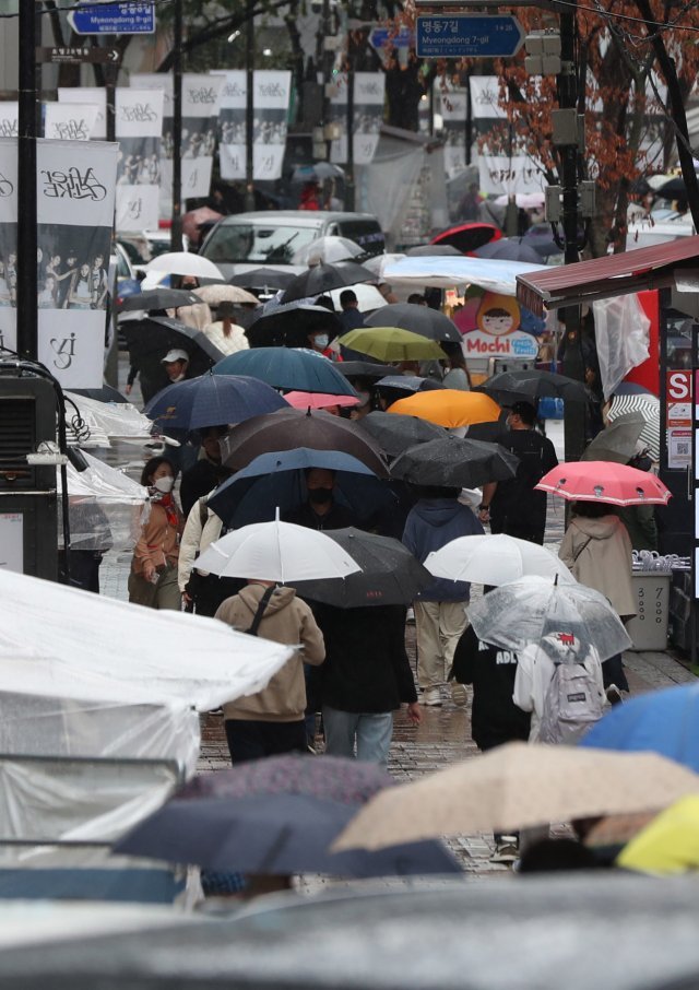 한글날 연휴 가을비가 내린 9일 오후 서울 중구 명동거리에서 우산을 쓴 시민들이 발걸음을 옮기고 있다. 뉴시스