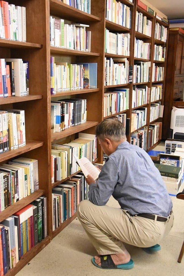 독서광인 문재인 전 대통령이 경남 양산 평산마을 사저에 마련된 서가에서 책을 찾아 잠시 독서 삼매경에 빠져 있는 모습. (SNS 갈무리) ⓒ 뉴스1