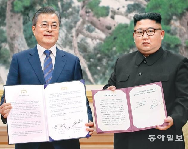 문재인 대통령(왼쪽)과 김정은 국무위원장이 2018년 9월 19일 평양 백화원 영빈관에서 평양공동선언문에 서명한 후 합의서를 들어 보이고 있다. 원대연 기자 yeon72@donga.com