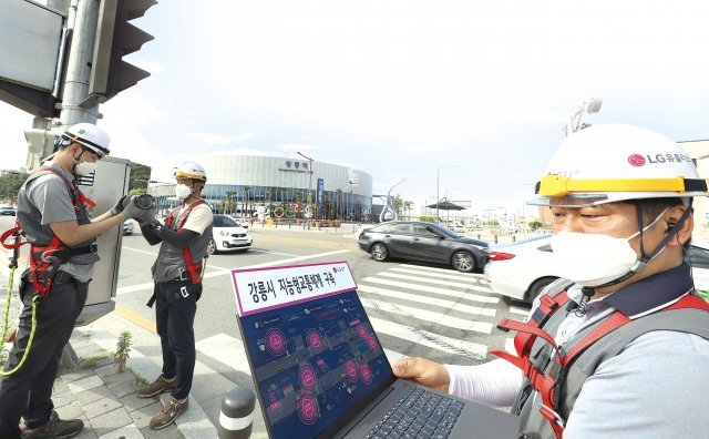 강원 강릉역 앞에서 LG유플러스 직원들이 스마트 횡단보도 서비스에 필요한 카메라를 설치하고 있다.