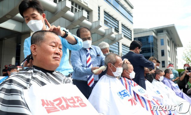 한국후계농업경영인 전라북도연합회 관계자들이 14일 전북 전주시 전북도청 앞에서 전북후계농업경연인 시군대표자 결의대회를 열고 쌀·농축산물 가격보장 및 양곡관리법 개정 촉구 삭발식을 하고 있다. 2022.9.14/뉴스1