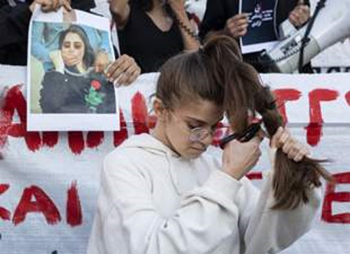 22세 이란 여성이 ‘히잡 착용 불량’으로 체포된 후 의문사한 사건의 진상 규명을 촉구하는 시위가 지난달 24일 그리스 아테네 신타그마 광장에서 열렸다. 한 여성이 항의 표시로 머리카락을 자르고 있다. 아테네=AP 뉴시스