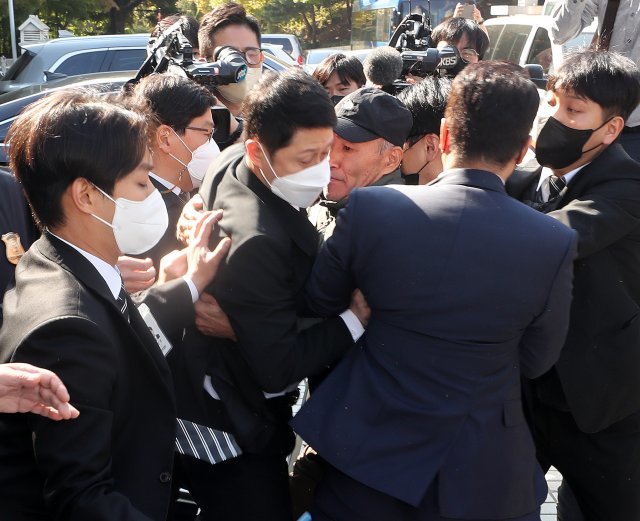 서해 피살 공무원 고(故) 이대준 씨의 친형 이래진 씨가 21일 서울 서초구 서울중앙지방법원에서 구속 전 피의자 심문(영장실질심사)를 마치고 나오는 서욱 전 국방부 장관을 향해 달려드는 중 경호원들에게 제지 당하고 있다. 2022.10.21/뉴스1