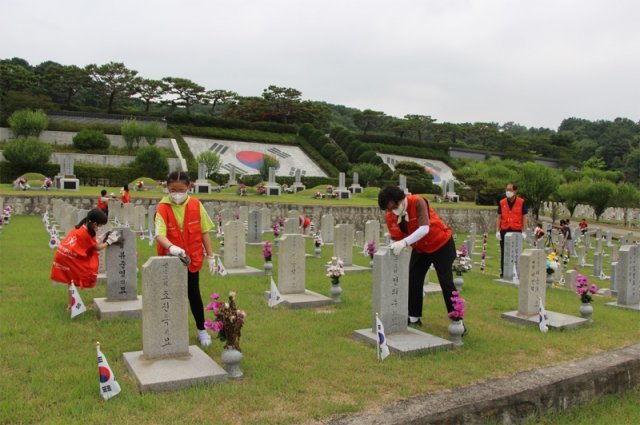 국립서울현충원에서 봉사자들이 순국선열들의 묘비를 정성스레 닦고 있다.