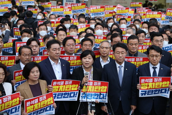 더불어민주당 의원들이 19일 오후 압수수색 중인 서울 여의도 더불어민주당사 앞에서 항의 손 피켓을 들고 있다. 서울중앙지검은 이날 대장동, 위례신도시 개발사업 특혜 의혹 사건과 관련해 민주당사 내 김용 민주연구원 부원장의 사무실 압수수색을 시도 했다. 2022.10.19 뉴스1