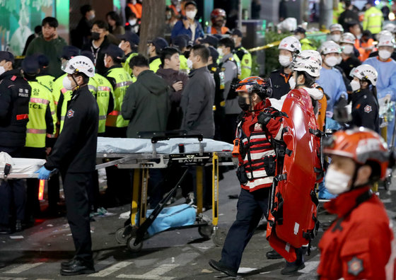 29일 밤 서울 용산구 이태원 한복판에서 심정지 환자가 대규모로 발생했다.  사진은 30일 사고가 발생한 서울 용산구 이태원 사고현장에서 소방 관계자가 이동식 침대를 옮기는 모습. 2022.10.30/뉴스1