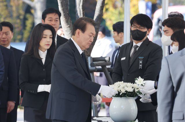 윤석열 대통령과 부인 김건희 여사가 31일 서울광장에 마련된 이태원 사고 사망자 합동분향소에서 국화꽃을 집어 들고 있다. 대통령실통신사진기자단