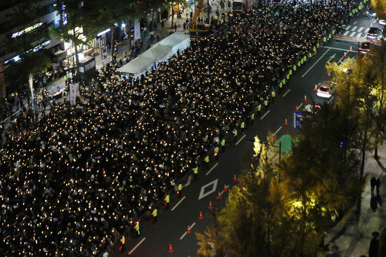 촛불행동 회원과 시민들이 5일 오후 서울 시청역 앞에서 열린 이태원 참사 희생자 추모촛불집회에서 촛불을 들고 있다. ⓒ News1