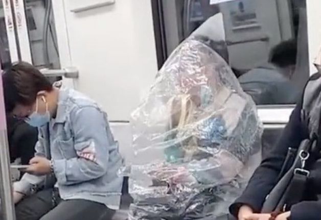 중국 우한 지하철에서 비닐을 뒤집어쓰고 바나나를 먹는 여성 승객이 포착됐다. (트위터 갈무리)