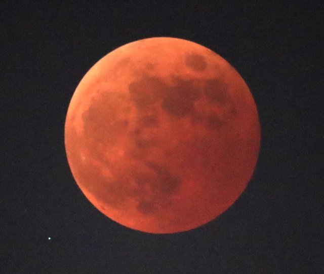 8일 저녁 개기월식에서 지구의 그림자에 완전히 가린 달이 붉게 보인다. 왼쪽 아래 천왕성이 보인다.