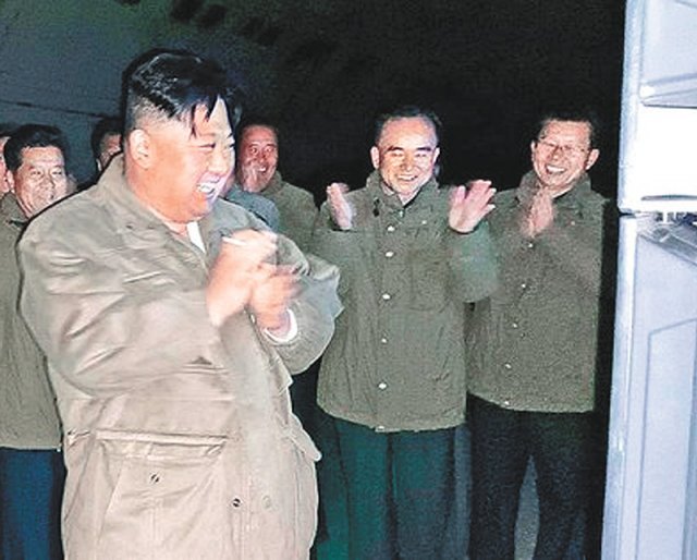 지난달 12일 장거리 전략순항미사일 시험 발사를 현장에서 지켜보던 김정은이 북한 간부들과 함께 박수를 치며 웃고 있다.  사진 출처 노동신문