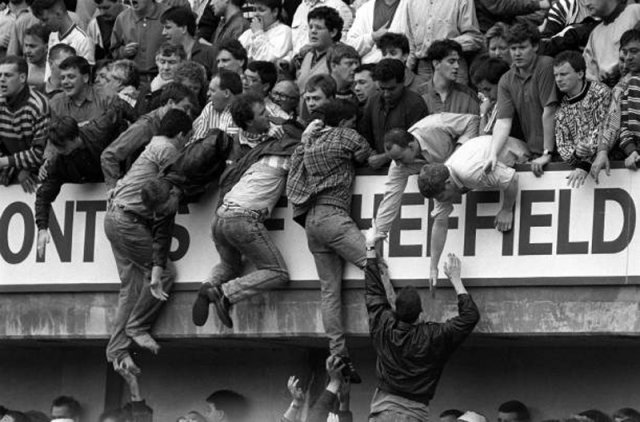 1989년 4월 15일 영국 프로축구 FA컵 리버풀과 노팅엄 포리스트의 준결승전이 열린 셰필드 힐즈버러 축구경기장에서 원정 응원에 나선 리버풀 팬들이 1층 관람석으로 과도하게 밀려 들어오는 관중의 압박을 못 견디고 위층으로 탈출하고 있다. 게티이미지코리아