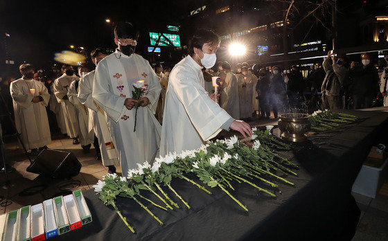 14일 오후 중구 서울파이낸스센터 앞에서 천주교정의구현전국사제단 주최로 열린 용산 이태원 참사 희생자를 위한 추모미사에 참석한 신부님들이 헌화를 하고 있다. 2022.11.14/뉴스1