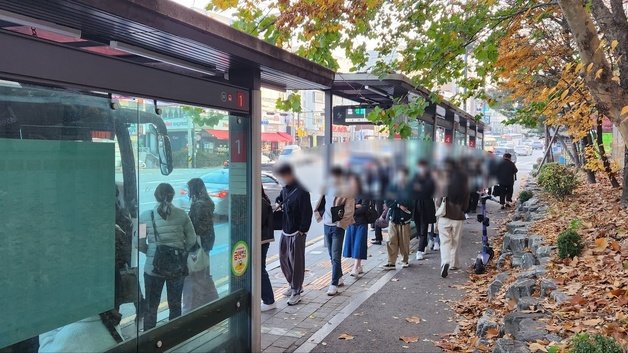 광역버스 입석 승차 금지 첫 날 오전 수원시 우만동4단지 버스정류장 앞에서 승객들이 줄을 서 버스를 기다리고 있다. /뉴스1