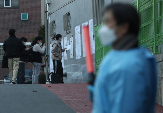 2023학년도 수능일인 17일 오전 수험생들이 시험장인 서울 강남구 개포고에서 자신의 고사장을 확인하고 있다. 오른쪽은 입실 안내하는 방역 관계자. 2022.11.17/뉴스1 ⓒ News1