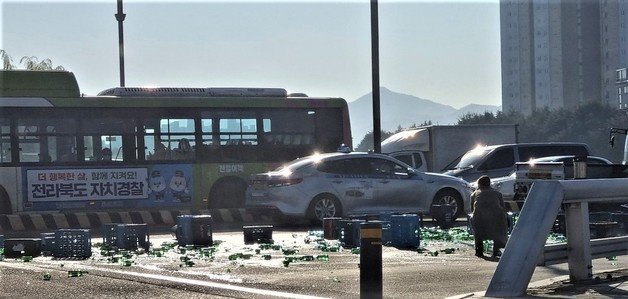 18일 오전 9시35분께 전북 전주시 완산구 서신동 백제교에서 화물차에 실려있던 소주 상자가 도로 위로 쏟아졌다.(독자 제공)2022.11.18/뉴스1