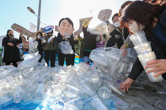 서울환경연합 관계자들이 10월18일 오전 서울 용산구 전쟁기념관 앞에서 열린 ‘일회용 컵 보증금제 무력화하는 윤석열 정부 규탄 기자회견’에서 일회용 컵 보증금제 시행을 촉구하는 퍼포먼스를 하고 있다. 서울환경연합은 이날 “2020년 자원재활용법 개정 이후 무려 2년의 준비기간이 있었으나 환경부의 악의적인 직무유기로 일회용 컵 보증금제도는 시행도 되기 전에 일방적으로 연기되고 대폭 축소됐다“고 주장했다. 2022.10.18/뉴스1