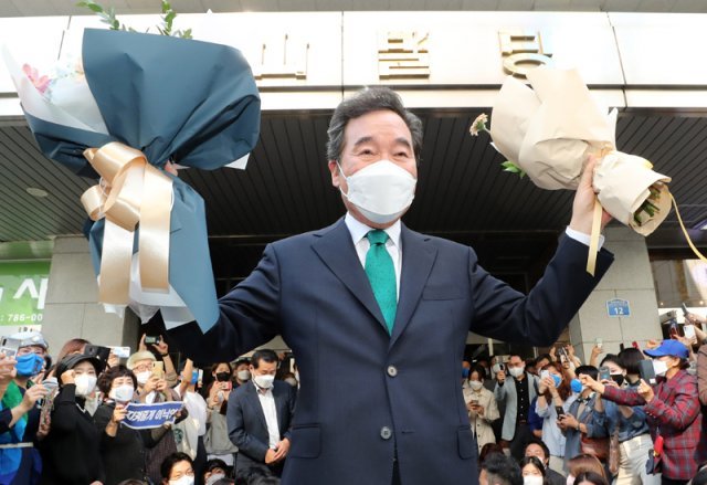 이낙연 전 더불어민주당 대표가 지난해 10월 14일 서울 여의도 대산빌딩에서 열린 필연캠프 해단식을 마친 뒤, 꽃다발을 들고 지지자들을 향해 손을 들고 있다. 사진공동취재단