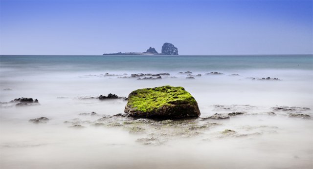 [대상] 김은주 ‘형제섬을 바라보며’ 이끼 낀 녹색 돌을 소재 삼아 제주 서귀포시 형제섬을 배경으로 촬영했다. 포근한 바다와 하늘색을 담았고, 장노출 촬영으로 파도의 흐름을 부드럽게 표현했다.