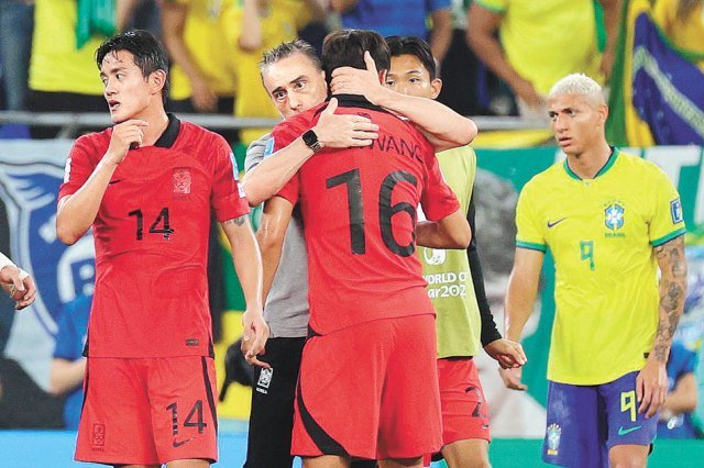 파울루 벤투 한국 감독(왼쪽에서 두 번째)이 6일 카타르 월드컵 브라질과의 16강전에서 1-4로 패한 뒤 선수들을 격려하고 있다. 도하=뉴스1