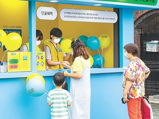 서울 양천구 신영시장의 디지털 튜터들이 상주했던 부스 앞에서 고객들이 카카오톡 채널 구독 방법 등에 대한 정보를 얻고 있다. 카카오 제공