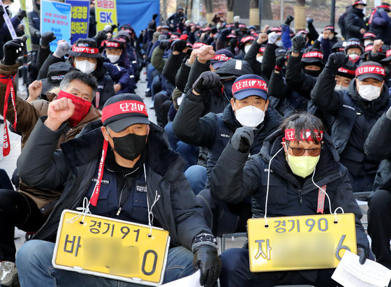 민주노총 공공운수노조 화물연대 인천지역본부 조합원들이 7일 서울 종로구 SK서린빌딩 앞에서 총력 결의대회를 갖고 안전운임제 일몰제 폐지 및 사측이 단체교섭에 임할 것을 요구하고 있다. 2022.12.7/뉴스1