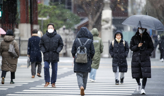 서울 등 수도권과 충청지역에 눈이 내린 6일 오전 서울 시내 한 거리에서 시민들이 눈을 맞으며 거리를 지나고 있다. 2022.12.6/뉴스1