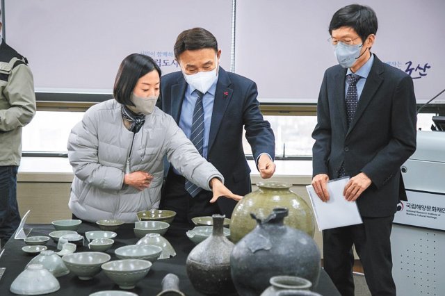 6일 전북 군산시청에서 진행된 고군산군도 해역 수중발굴조사 성과보고회에서 강임준 군산시장(가운데)과 국립해양문화재연구소 관계자 등이 발굴된 유물을 살펴보고 있다. 군산시 제공