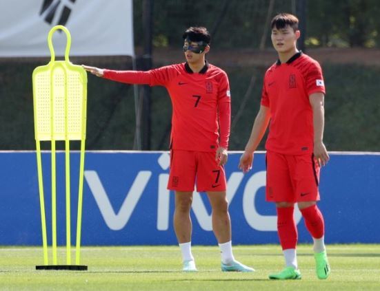 대한민국 축구대표팀 손흥민이 16일(현지시간) 오전 카타르 도하 알 에글라 트레이닝센터에서 수술한 왼쪽 눈 주위를 보호할 마스크를 쓰고 예비명단 오현규와 훈련을 하고 있다. [도하(카타르)=뉴시스]