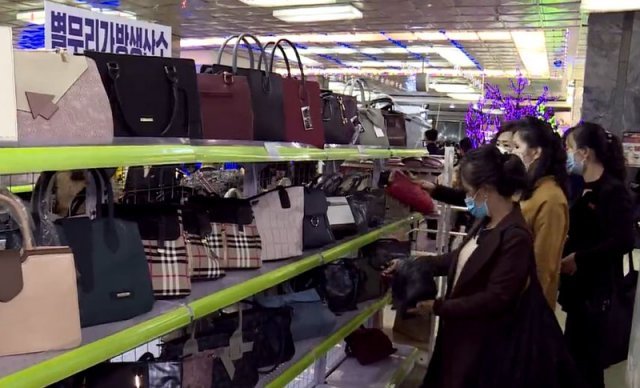 10월 북한 평양에서 열린 평양제1백화점 상품전시회에서 주민들이 진열대 위의 가방들을 구경하고 있다. 영국 명품 브랜드 ‘버버리’
 디자인을 도용한 것으로 추정되는 제품도 보인다. 북한의 대외선전매체 ‘조선의오늘’ 웹사이트에 올라온 장면이다. 북한 
‘조선의오늘’ 캡처