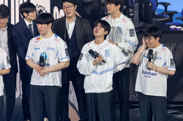 지난달 5일(현지시간) 미국 샌프란시스코 체이스센터에서 열린 리그오브레전드 세계 대회(롤드컵) 결승전에서 데프트(앞줄 왼쪽 두번째·본명 김혁규)가 인터뷰 중 감정이 북받쳐 오른 듯 눈물을 참고 있다. 라이엇게임즈 제공