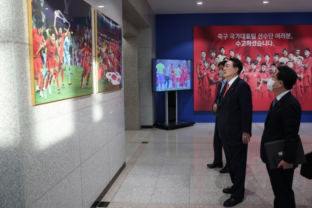 윤석열 대통령이 13일 용산 대통령실 청사 로비에 전시된 카타르 월드컵 축구 국가대표팀 기념사진 및 기념품을 살펴보고 있다. 2022.12.13. 대통령실 제공