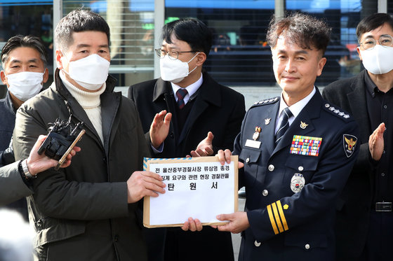 행정안전부 경찰국 신설에 반대하며 전국경찰서장(총경) 회의를 주도했던 류삼영 총경(전 울산중부경찰서장)이 지난 8일 오후 서울 서대문구 경찰청에서 열린 징계위원회에 출석하기 앞서 직장협의회 동료 경찰들의 탄원서를 전해 받고 있다. 뉴스1