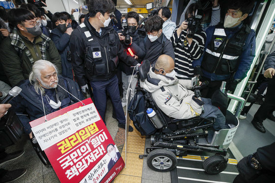 전국장애인차별철폐연대(전장연) 회원들이 13일 오전 서울 용산구 삼각지역에서 장애인 권리 예산 확보를 위한 지하철 타기 선전전을 위해 이동하고 있다. 2022.12.13/뉴스1 ⓒ News1