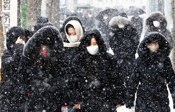 서울, 경기 등 수도권 전역과 중부 지방 곳곳에 대설주의보가 내려진 15일 서울 서초구 법원 삼거리에서 시민들이 내리는 눈을 피하기 위해 걸음을 재촉하고 있다. 2022.12.15 뉴스1