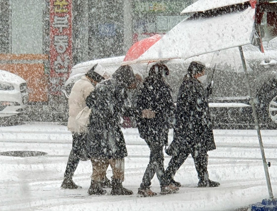 대설주의보가 내려진 17일 광주 한 도로에서 보행자들이 폭설 속에서 조심스레 걸어가고 있다. 2022.12.17 뉴스1