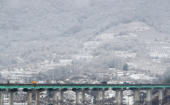 경북 문경과 북동 산지에 대설주의보가 발효된 13일 오후 문경읍 백화산 자락에 흰 눈에 뒤덮여 인근 중부내륙고속도로를 지나는 차량이 거북이운행을 하고 있다. 2022.12.13/뉴스1