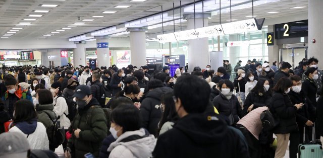 18일 오전 기상악화로 제주를 오가는 항공기 90여편이 결항된 가운데 제주국제공항이 관광객들로 붐비고 있다. 현재 제주 산지에는 대설경보, 제주 전역에는 대설주의보와 강풍주의보가 내려졌다.2022.12.18/뉴스1