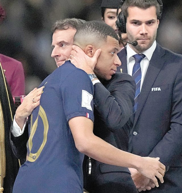 에마뉘엘 마크롱 프랑스 대통령이 19일 아르헨티나와의 월드컵 결승전이 끝난 뒤 프랑스의 에이스 킬리안 음바페(앞)를 안아주고 있다. 루사일=AP 뉴시스