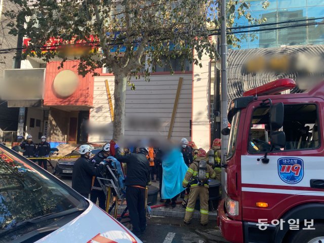 23일 대구 동구 신천동 성인 무도장에서 방화로 추정되는 불이 난 가운데 소방대원들이 구조한 부상자를 이송하고 있다. 대구소방본부 제공