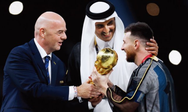 타밈 카타르 국왕(가운데)과 잔니 인판티노 FIFA 회장(왼쪽)이 리오넬 메시에게 월드컵 우승 트로피를 건네고 있다. [뉴시스]