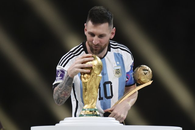 아르헨티나의 리오넬 메시가 19일(한국시간) 루사일 스타디움에서 벌어진 프랑스와 2022카타르월드컵 결승전에서 승리한 뒤 처음으로 거머쥔 우승 트로피를 만져보며 기뻐하고 있다. 루사일(카타르)=신화 뉴시스