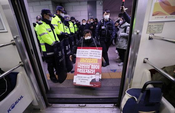 전국장애인차별철폐연대(전장연) 회원들이 지난 19일 오전 서울 지하철1호선 서울역에서 장애인 권리 예산 확보를 위한 지하철 타기 선전전을 하고 있다. 오세훈 서울시장의 ‘잠정 중단’ 요청에 따라 21일부터 시위를 중단했던 전장연은 요구했던 예산증액이 거의 이뤄지지 않았다며 오는 1월2일부터 다시 시위를 재개키로 했다. ⓒ News1